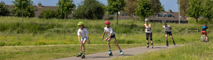 Gezin skeelert op een fietspad in Bos Nieuw Wulven