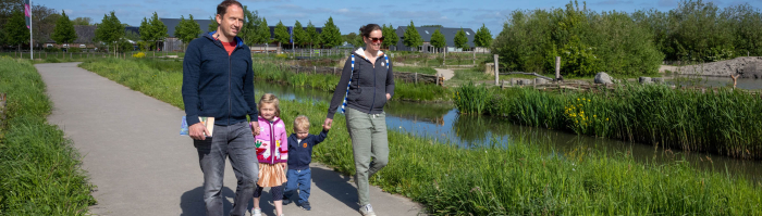 Gezin wandelt temidden van gras en speelplaats in Haarzuilens