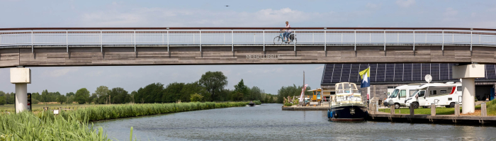 Fietser passeert op de fietsbrug de Hollandsche IJssel bij haven Marnemoende