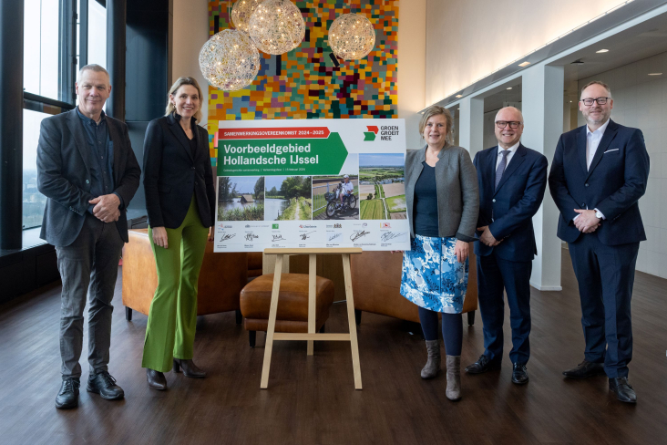 Vijf bestuurders poseren bij een bord met handtekening voor de samenwerkingsovereenkomst