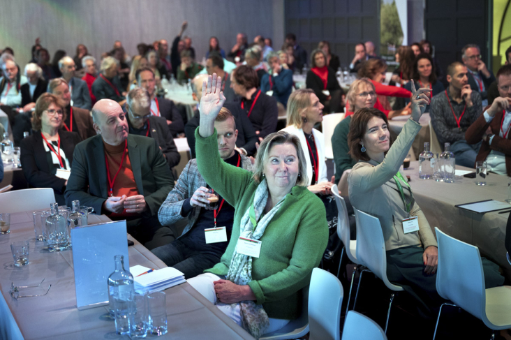 Deelnemers steken hun hand op tijdens de Groen Groeit Mee Conferentie